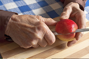 Hands cutting an apple with a knife