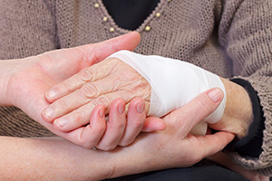 One hand holding a bandaged hand